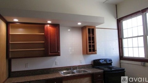 A kitchen with brown cabinets and a black stove top oven.