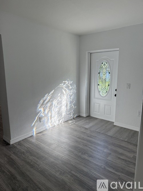A room with a door and a window with a stained glass design.