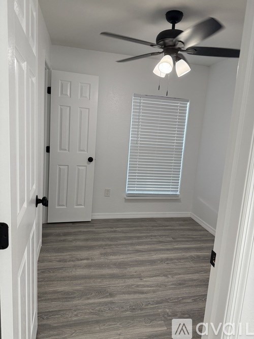 A room with a ceiling fan and a closed door.