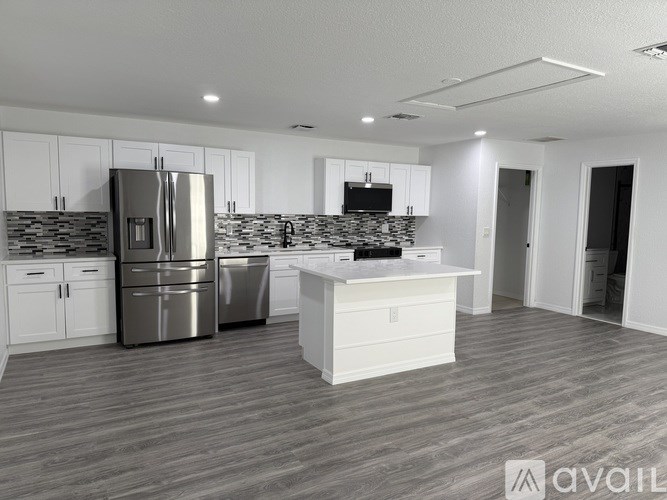A modern kitchen with a refrigerator, microwave, and a countertop.