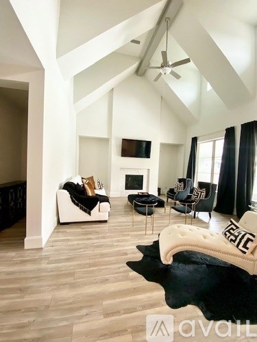 A living room with a white couch and a black cowhide rug.