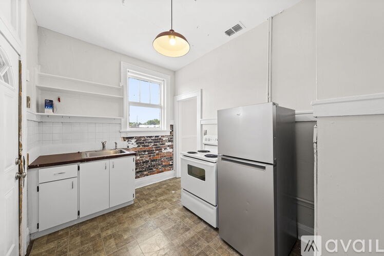 A kitchen with white cabinets and a refrigerator.