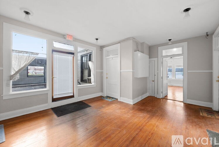 A spacious room with wooden floors and white walls.