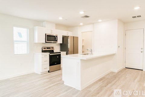 A kitchen with white cabinets and a wooden floor.