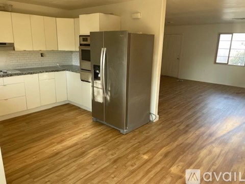 A kitchen with a refrigerator, oven, and microwave.