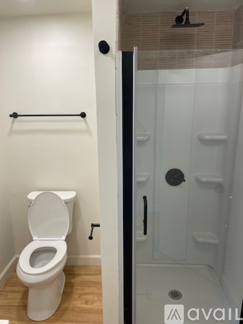 A white toilet in a small bathroom with a glass shower door.