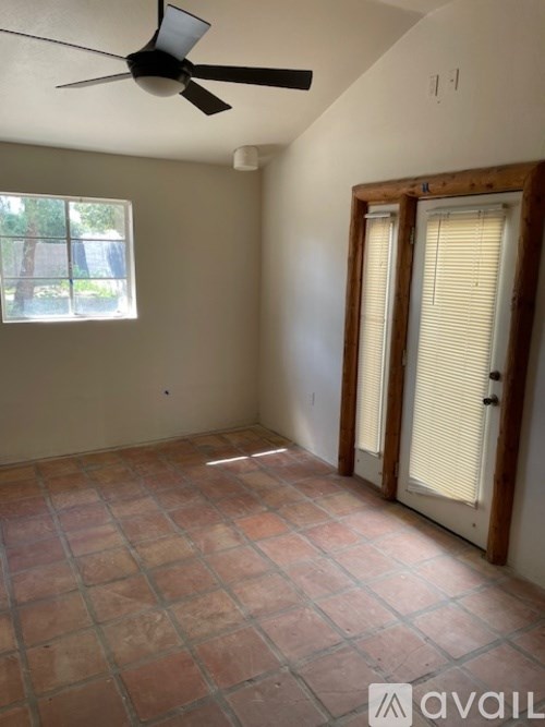 A room with a ceiling fan and tiled floor.