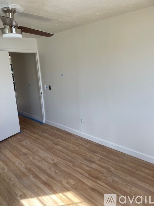 A room with a wooden floor and a ceiling fan.