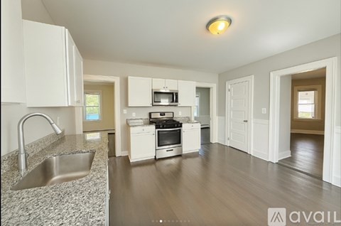 A kitchen with white cabinets and a stainless steel sink.
