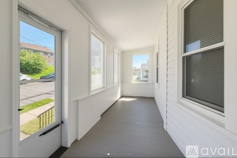 A balcony with a view of a street and houses.