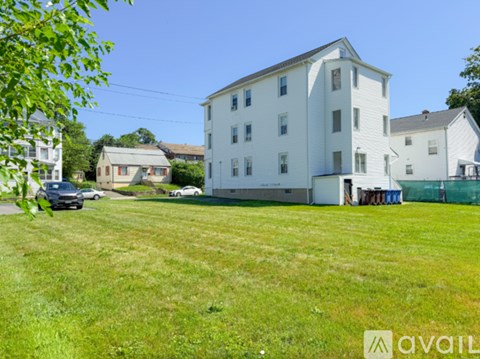 A large white building with a green lawn in front of it.