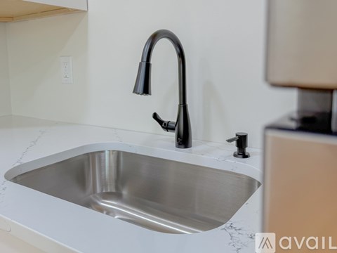 A modern kitchen sink with a black faucet.