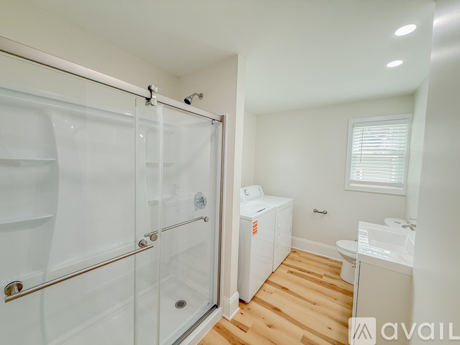 A bathroom with a glass shower stall and a white cabinet.