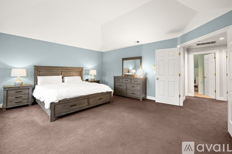 A bedroom with a bed, dresser, and mirror.