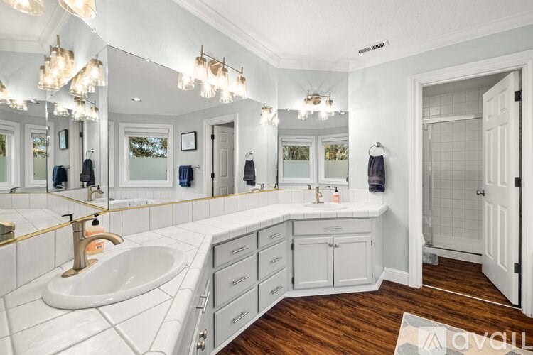 A bathroom with a white sink and a large mirror.