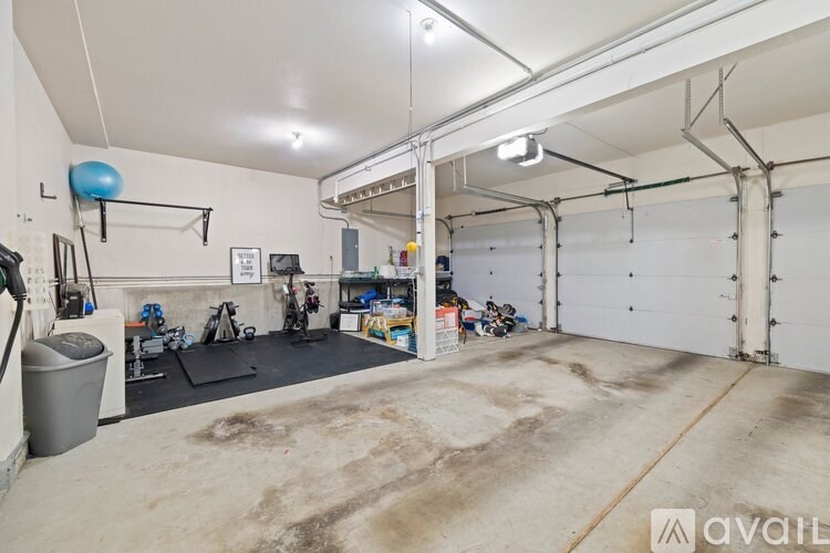 A spacious garage with a blue exercise ball hanging from the ceiling.