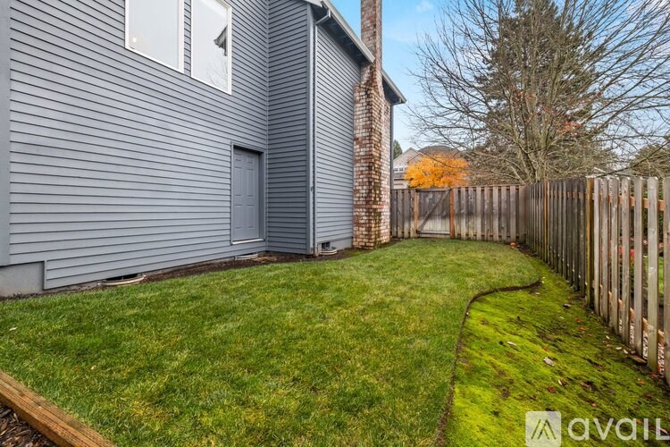 A house with a grey exterior and a wooden fence.
