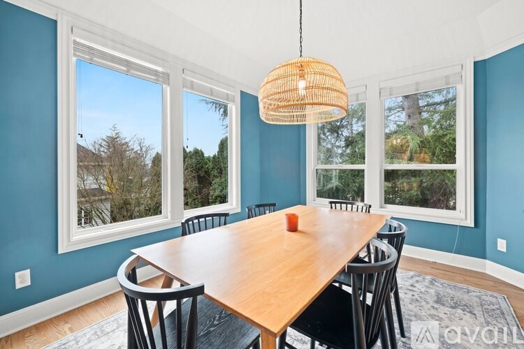 A dining room with a wooden table and chairs.