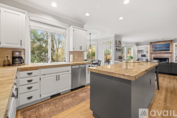 A kitchen with a large island and wooden floors.