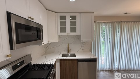 A kitchen with a black stove top oven and a black microwave above it.