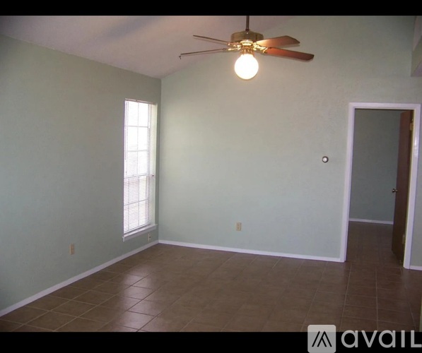 A room with a ceiling fan and a window.