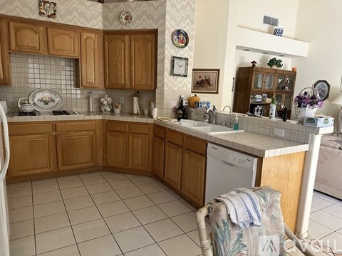 A kitchen with wooden cabinets and a white dishwasher.