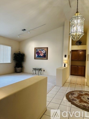 A living room with a painting on the wall and a rug on the floor.
