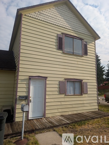 A house with a white door and two windows with shutters.