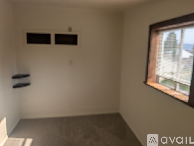 A room with a window and a wall-mounted air conditioner unit.