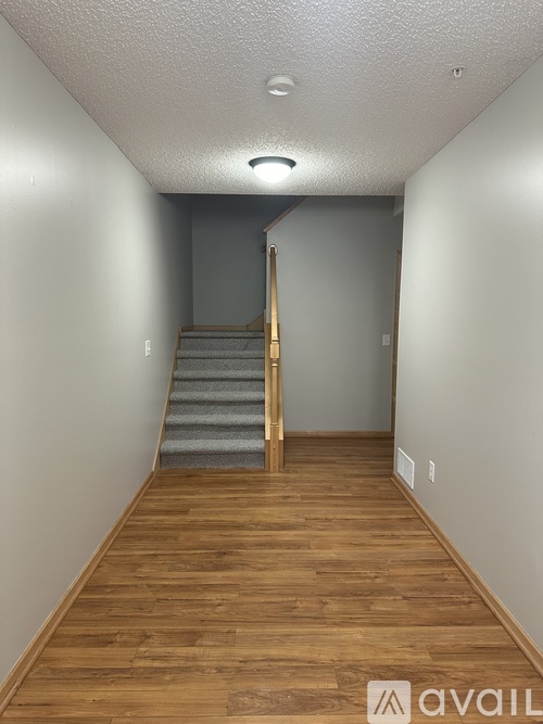 A hallway with wooden floors and a staircase.