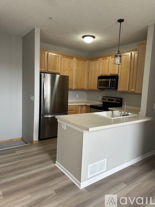 A kitchen with wooden cabinets and a white island.