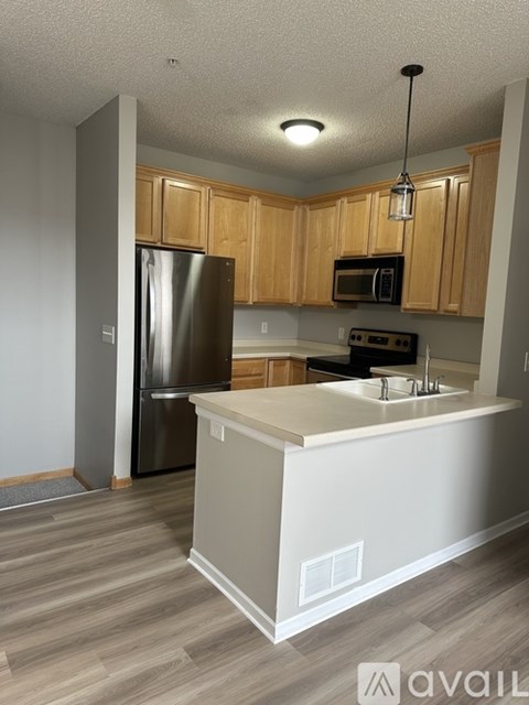 A kitchen with wooden cabinets and a white island.