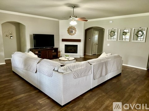 A living room with a white couch and a fireplace.