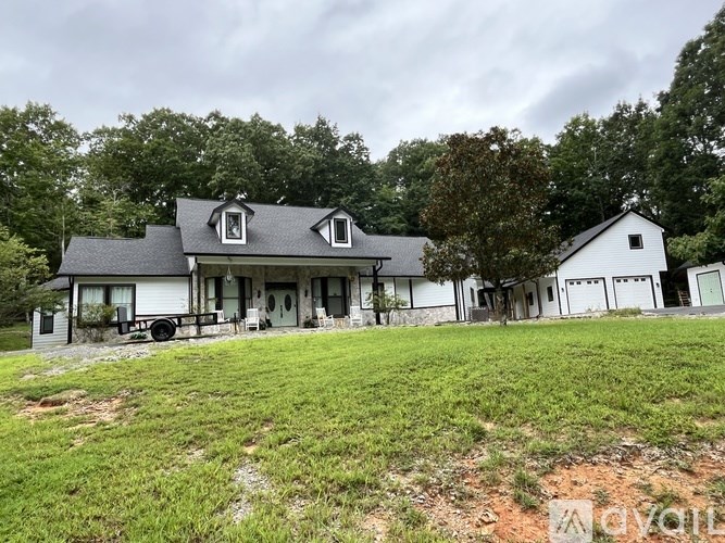 A white house with a black roof and a front porch.