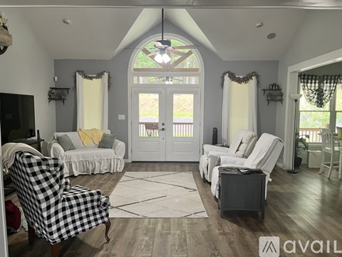 A living room with a checkered chair and a television.