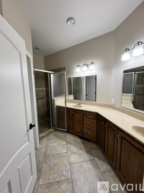 A bathroom with a sink, mirror, and shower.