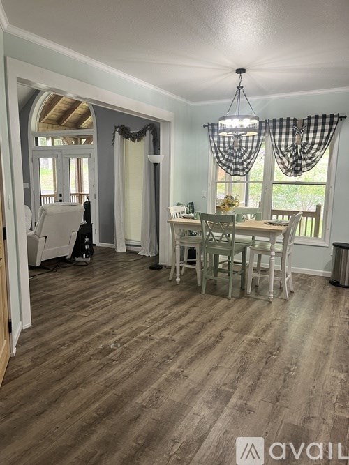 A dining room with a checkered curtain and a wooden floor.