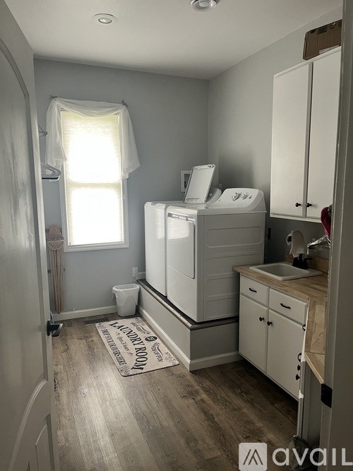 A small bathroom with a toilet, sink, and cabinets.