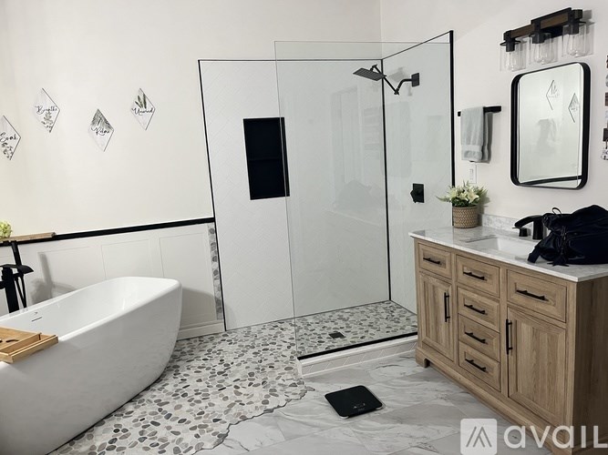 A modern bathroom with a white bathtub, a walk-in shower, and a wooden vanity.