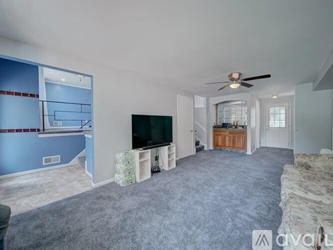A living room with a television and a staircase.