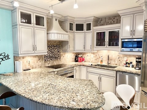 A kitchen with granite countertops and white cabinets.