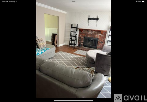 A living room with a grey couch and a fireplace.