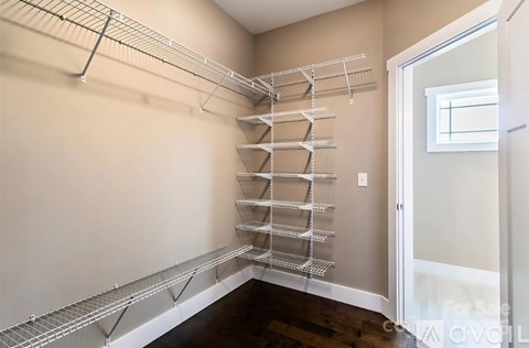 A walk-in pantry with a white door and shelves.