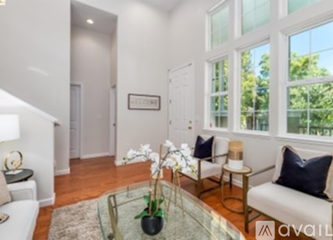 A living room with a glass coffee table and a white sofa.