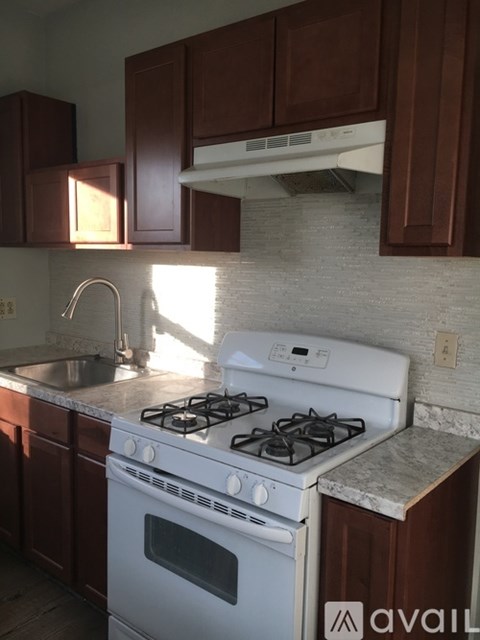 A white gas stove in a kitchen with brown cabinets.