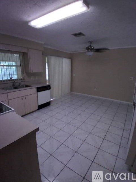 A kitchen with white cabinets and a tile floor.