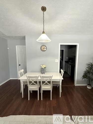 A dining room with a white table and chairs.