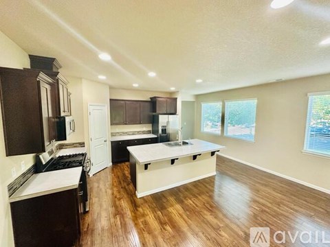 A kitchen with dark wood cabinets and a white island.