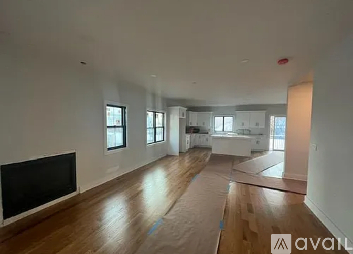 A spacious living room with wooden floors and a television.