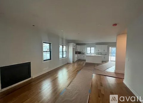 A spacious living room with wooden floors and a television.